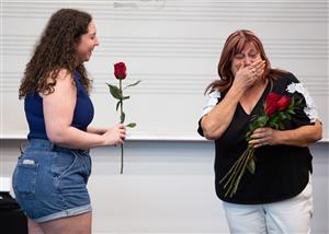 Deidre Deal receives a rose from a former student